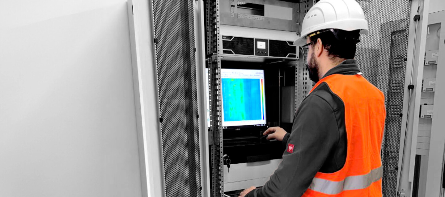 Project Manager in Action AP Sensing: Techniker konfiguriert faseroptisches Überwachungssystem im Server-Rack