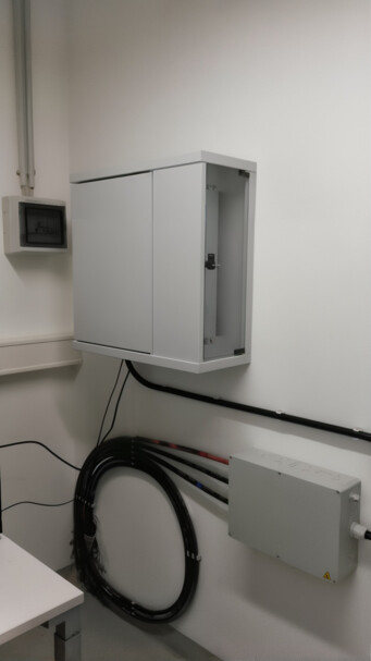 19” AP Sensing DTS device mounted in a flat wall cabinet Infrastructure installation with equipment cabinet and coiled fiber optic cable for AP Sensing