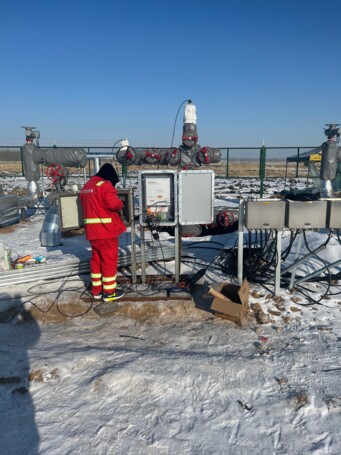 Worker installing AP Sensing Distributed Temperature Sensing system for pipeline monitoring in a snowy field Worker installing AP Sensing Distributed Temperature Sensing system for pipeline monitoring in a snowy field