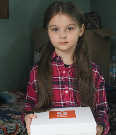 Young girl holding a white box with an orange logo sticker Young girl holding a white box with an orange logo sticker
