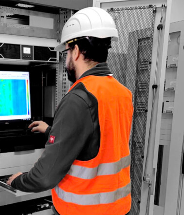 Project Manager in Action AP Sensing: Techniker konfiguriert faseroptisches Überwachungssystem im Server-Rack