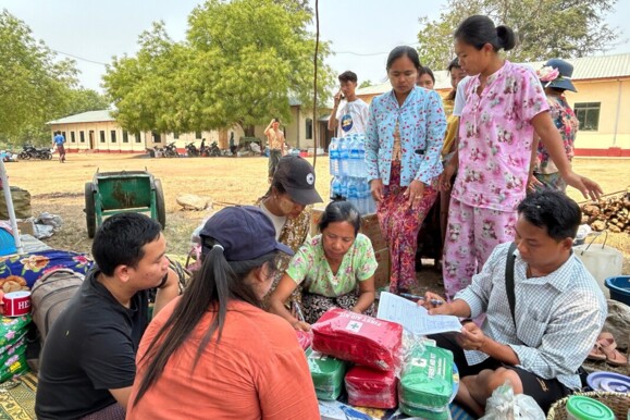 Community receiving essential aid, highlighting the need for infrastructure monitoring to prevent disruptions